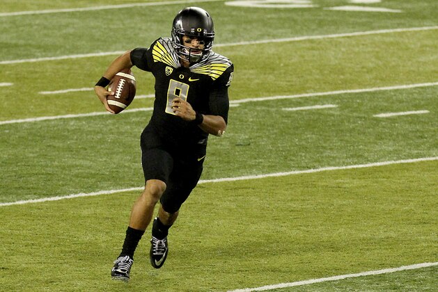 Oregon quarterback Marcus Mariota (8) runs towards the end zone during the fourth quarter against Stanford in an NCAA college football game in Eugene, Ore., Saturday, Nov. 1, 2014. (AP Photo/Ryan Kang)