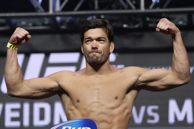 Lyoto Machida poses on the scale during a weigh-in for the UFC 175 mixed martial arts event at the Mandalay Bay, Friday, July 4, 2014, in Las Vegas. Machida is scheduled to fight Chris Weidman in a middleweight title bout on Saturday in Las Vegas. (AP Photo/John Locher)