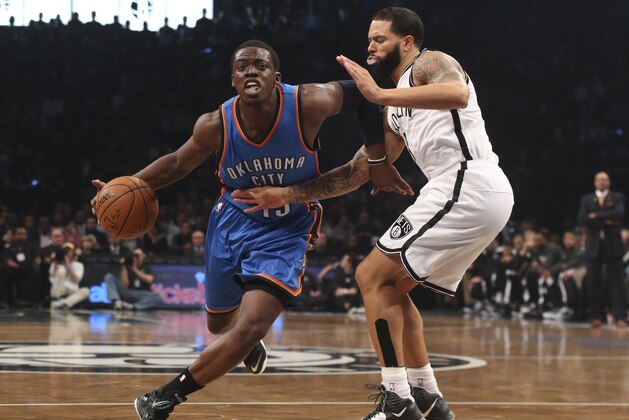 Oklahoma City Thunder guard Reggie Jackson (15) drives past Brooklyn Nets guard Deron Williams (8) in the first half of an NBA basketball game at the Barclays Center, Monday, Nov. 3, 2014, in New York. (AP Photo/John Minchillo)