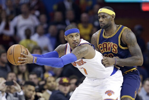 New York Knicks' Carmelo Anthony, left,  keeps the ball away from Cleveland Cavaliers' LeBron James during an NBA basketball game Thursday, Oct. 30, 2014, in Cleveland. (AP Photo/Tony Dejak)
