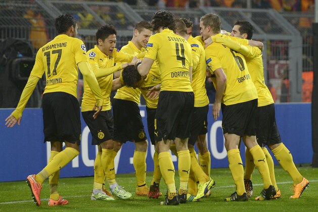 Dortmund's Sokratis, center, partially hidden, is congratulated by his teammates after scoring their side's second goal during the Champions League group D soccer match between Borussia Dortmund and Galatasaray Istanbul in Dortmund, Germany, Tuesday, Nov.4, 2014. (AP Photo/Martin Meissner)