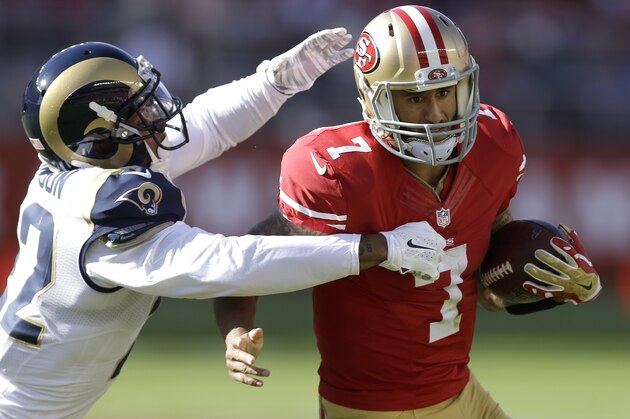San Francisco 49ers quarterback Colin Kaepernick (7) runs from the grasp of St. Louis Rams cornerback Trumaine Johnson during the second quarter of an NFL football game in Santa Clara, Calif., Sunday, Nov. 2, 2014. (AP Photo/Ben Margot)