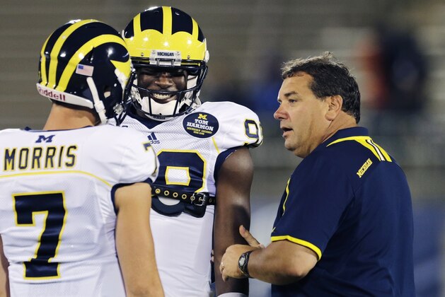 Michigan head coach Brady Hoke, right, talks with quarterbacks Devin Gardner, center, and Shane Morris (7) before an NCAA college football game against Connecticut, Saturday, Sept. 21, 2013, in East Hartford, Conn. (AP Photo/Charles Krupa)