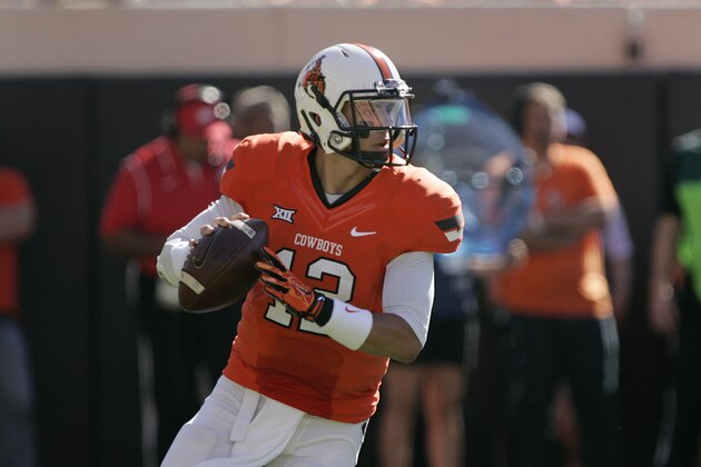STILLWATER, OK - OCTOBER 25:   Quarterback Daxx Garman #12 of the Oklahoma State Cowboys looks to throw against the West Virginia Mountaineers October 25, 2014 at Boone Pickens Stadium in Stillwater, Oklahoma. The Mountaineers defeated the Cowboys 34-10. (Photo by Brett Deering/Getty Images)