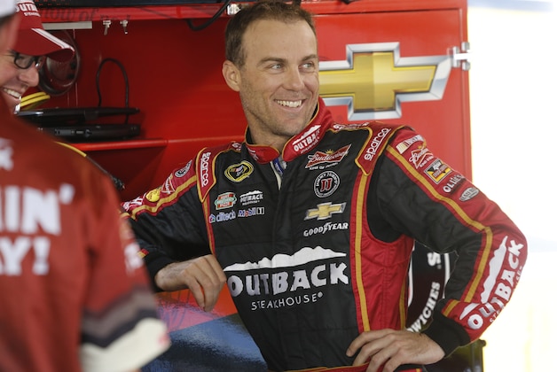 Kevin Harvick talks to his crew in the garage as he waits for practice to begin for Sunday's Sprint Cup Series auto race at Martinsville Speedway in Martinsville, Va., Saturday, Oct. 25, 2014. (AP Photo/Steve Helber)