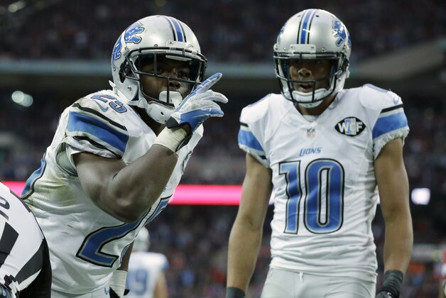 Detroit Lions running back Theo Riddick (25) celebrates a touchdown with wide receiver Corey Fuller (10) in the second half of the NFL football game against the Atlanta Falcons at Wembley Stadium, London, Sunday, Oct. 26, 2014.  (AP Photo/Matt Dunham)