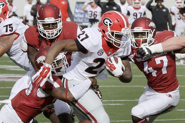 Georgia running back Nick Chubb (27) pushes past Arkansas defenders linebacker Martrell Spaight (47), safety Rohan Gaines, bottom left, and defensive end JaMichael Winston, top left, in the first quarter of an NCAA college football game in Little Rock, Ark., Saturday, Oct. 18, 2014. (AP Photo/Danny Johnston)