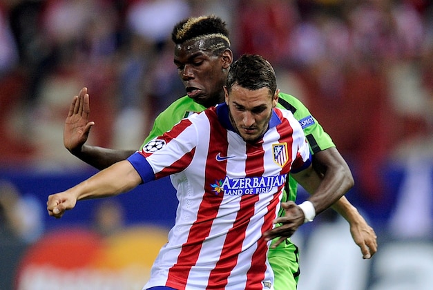 MADRID, SPAIN - OCTOBER 01:   Koke of Club Atletico de Madrid fends off Paul Pogba of Juventus during the UEFA Champions League Group A match between Club Atletico de Madrid and Juventus at Vicente Calderon Stadium on October 1, 2014 in Madrid, Spain.  (Photo by Denis Doyle/Getty Images)