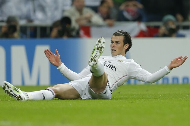 Real Madrid's Gareth Bale lies on the ground after colliding with Liverpool's Alberto Moreno, not pictured, during a Group B Champions League soccer match between Real Madrid and Liverpool at the Santiago Bernabeu stadium in Madrid, Spain, Tuesday Nov. 4, 2014. (AP Photo/Paul White)