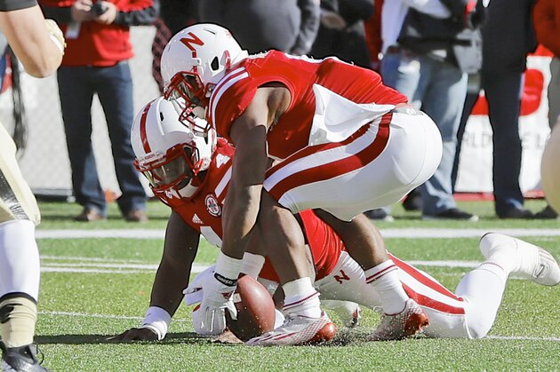 Nebraska running back Ameer Abdullah (8), recovers a ball which was fumbled by quarterback Tommy Armstrong Jr., rear, in the first half of an NCAA college football game against Purdue in Lincoln, Neb., Saturday, Nov. 1, 2014. (AP Photo/Nati Harnik)