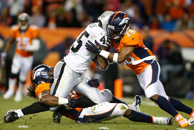 Sep 23, 2013; Denver, CO, USA; Oakland Raiders fullback Marcel Reece (45) is tackled by Denver Broncos linebacker Nate Irving (bottom) and safety Rahim Moore (26) during the second half at Sports Authority Field at Mile High.  The Broncos won 37-21. Mandatory Credit: Chris Humphreys-USA TODAY Sports