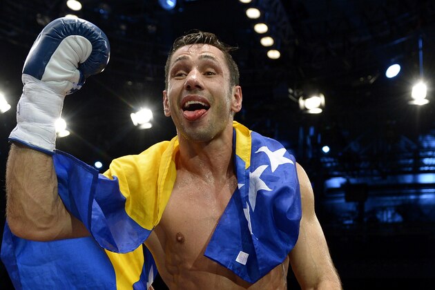 Challenger Felix Sturm from Germany celebrates his victory after his middleweight title bout against Darren Barker of Britain in Stuttgart, southern Germany, Saturday, Dec. 7, 2013. Sturm defeated defending champion  Barker with a second round TKO to take the Briton's IBF middleweight title on Saturday.  (AP Photo/Daniel Kopatsch)