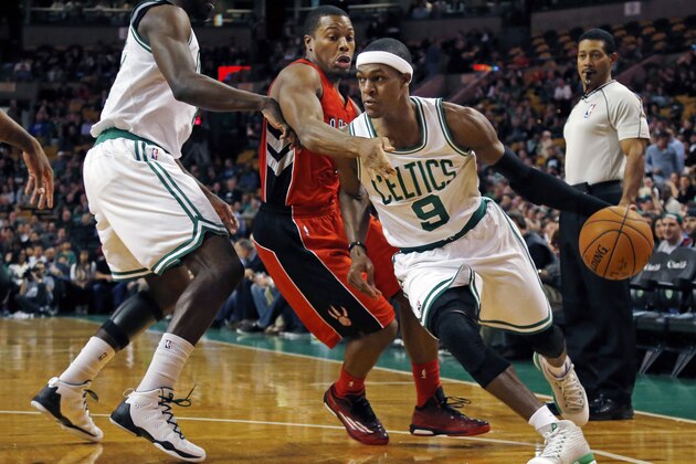 Boston Celtics guard Rajon Rondo (9) drives past Toronto Raptors guard Kyle Lowry, middle, during the first quarter of an NBA basketball game in Boston, Wednesday, Nov. 5, 2014. (AP Photo/Elise Amendola)