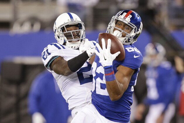 New York Giants tight end Larry Donnell (84) catches a pass in front of Indianapolis Colts' Vontae Davis (21) during the second half of an NFL football game Monday, Nov. 3, 2014, in East Rutherford, N.J.  (AP Photo/Kathy Willens)