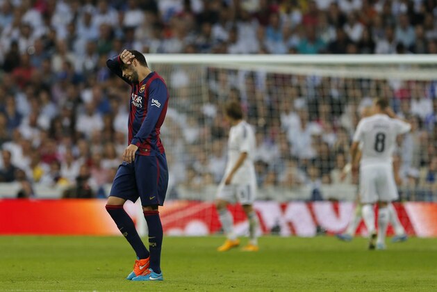 Barcelona's Gerard Pique rubs his brow during a Spanish La Liga soccer match between Real Madrid and Barcelona at the Santiago Bernabeu stadium in Madrid, Spain, Saturday Oct. 25, 2014. (AP Photo/Paul White)