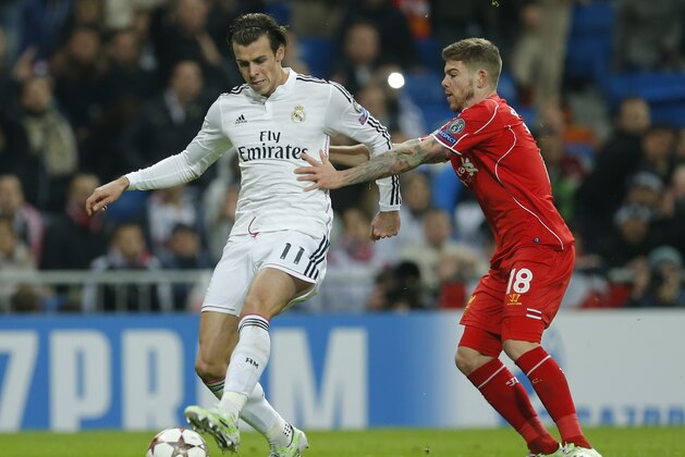 Real Madrid's Gareth Bale, left and Liverpool's Alberto Moreno fight for the ball during a Group B Champions League soccer match between Real Madrid and Liverpool at the Santiago Bernabeu stadium in Madrid, Spain, Tuesday Nov. 4, 2014. (AP Photo/Paul White)