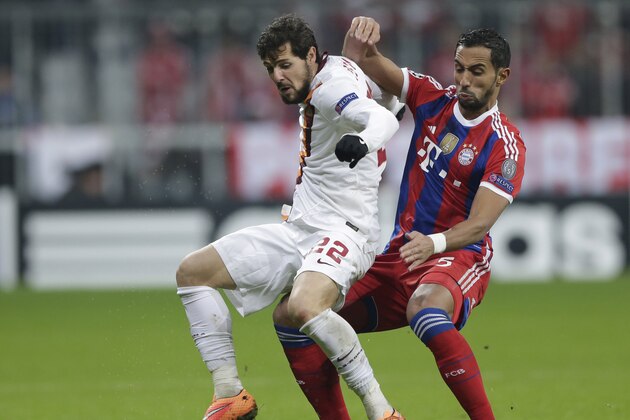 Bayern's Mehdi Benatia, right, and Roma's Mattia Destro  challenge for the ball during the Champions League Group E soccer match between FC Bayern Munich and AS Roma at Allianz Arena in Munich, southern Germany, Wednesday Nov. 5, 2014. (AP Photo/Matthias Schrader)