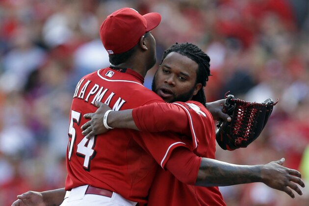 Cincinnati Reds starting pitcher Johnny Cueto, right, hugs relief pitcher Aroldis Chapman (54) after they defeated the Pittsburgh Pirates 4-1 in a baseball game, Sunday, Sept. 28, 2014, in Cincinnati. Cueto earned his 20th win and Chapman his 36th save. (AP Photo/Al Behrman)