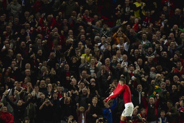 Manchester United's Robin van Persie removes his shirt as he celebrates after scoring an equalising goal against Chelsea, during the English Premier League soccer match between Manchester United and Chelsea at Old Trafford Stadium, Manchester, England, Sunday Oct. 26, 2014.  The game finished 1-1. (AP Photo/Jon Super)