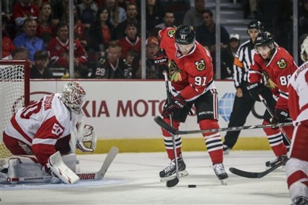 CORRECTS LAST NAME TO RICHARDS FROM RICHARDSON - Chicago Blackhawks' Brad Richards (91) tries to control the puck in front of Detroit Red Wings goalie Jonas Gustavsson in an NHL exhibition hockey game in Chicago on Tuesday, Sept. 23, 2014. (AP Photo/Charles Cherney)