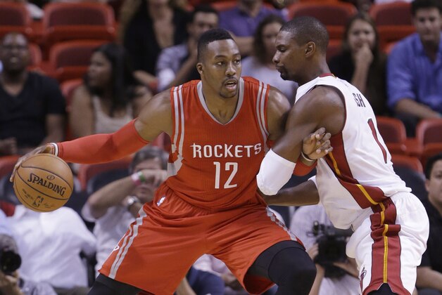 Houston Rockets center Dwight Howard (12) drives up against Miami Heat forward Chris Bosh during the first half of a preseason NBA basketball game, Tuesday, Oct. 21, 2014 in Miami. (AP Photo/Wilfredo Lee)