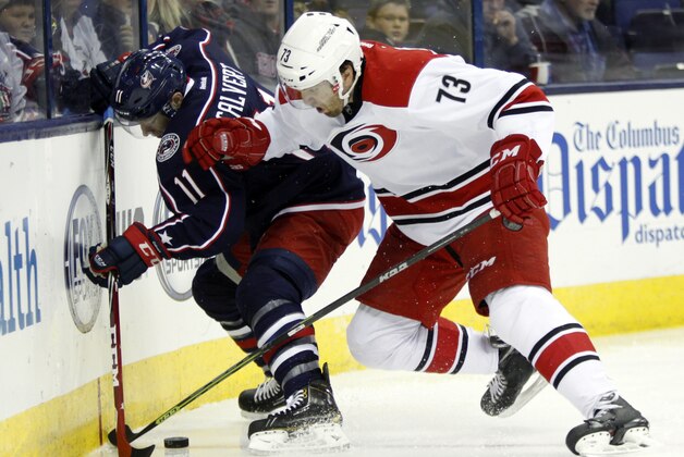 Columbus Blue Jackets' Matt Calvert, left, works for the puck against Carolina Hurricanes' Brett Bellemore during the second period of an NHL hockey game in Columbus, Ohio, Tuesday, Nov. 4, 2014. (AP Photo/Paul Vernon)