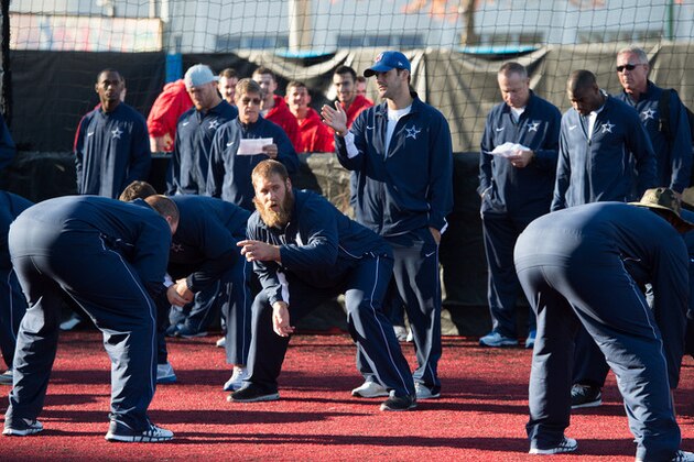 Dallas Cowboys quarterback Tony Romo, standing center, warms up with his team during a community day event outside Wembley Stadium in London, England, Tuesday Nov. 4, 2014. The Dallas Cowboys will play the Jacksonville Jaguars in an NFL football game at Wembley Stadium on Sunday Nov. 9. (AP Photo/Tim Ireland)