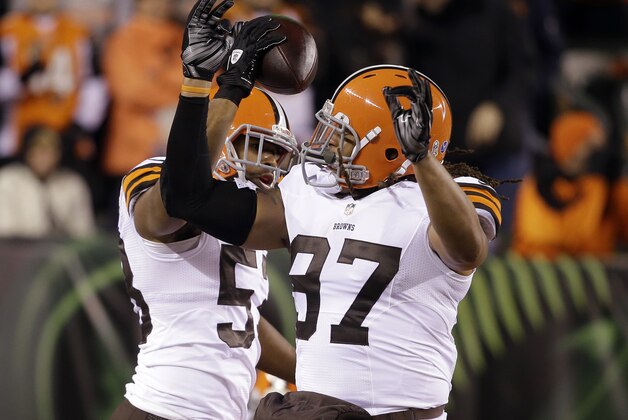 Cleveland Browns inside linebacker Craig Robertson (53) celebrates with Jabaal Sheard (97) after Robertson intercepted a pass during the first half of an NFL football game against the Cincinnati Bengals on Thursday, Nov. 6, 2014, in Cincinnati. (AP Photo/Darron Cummings)