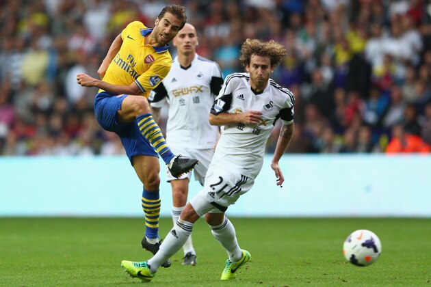 SWANSEA, WALES - SEPTEMBER 28: Mathieu Flamini (L) of Arsenal shoots past Jose Canas (R) of Swansea City during the Barclays Premier League match between Swansea City and Arsenal at the Liberty Stadium on September 28, 2013 in Swansea, Wales.  (Photo by Michael Steele/Getty Images)
