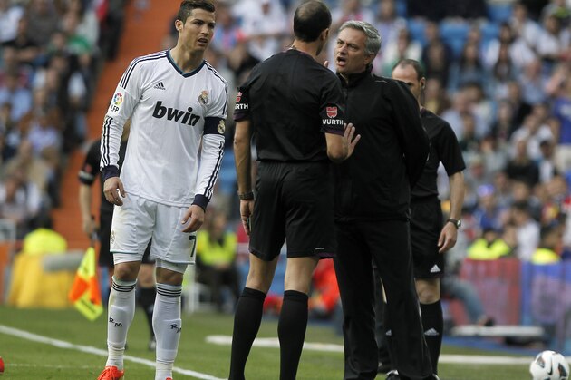 Real Madrid's coach Jose Mourinho from Portugal, right, and Cristiano Ronaldo from Portugal, left, talk to the referee Alvarez Izquierdo, centre, during a Spanish La Liga soccer match against Betis at the Santiago Bernabeu stadium in Madrid, Spain, Saturday, April 20, 2013. (AP Photo/Andres Kudacki)