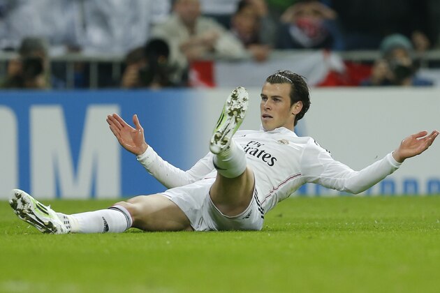 Real Madrid's Gareth Bale lies on the ground after colliding with Liverpool's Alberto Moreno, not pictured, during a Group B Champions League soccer match between Real Madrid and Liverpool at the Santiago Bernabeu stadium in Madrid, Spain, Tuesday Nov. 4, 2014. (AP Photo/Paul White)