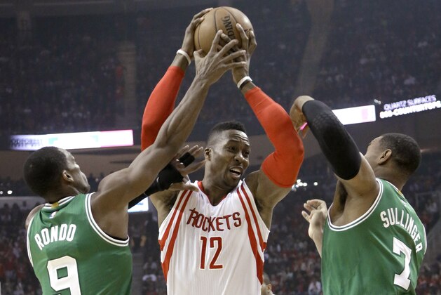 Houston Rockets' Dwight Howard (12) goes to the basket as Boston Celtics Rajon Rondo (9) and Jared Sullinger (7) defend during the first half of an NBA basketball game Saturday, Nov. 1, 2014, in Houston. (AP Photo/Pat Sullivan)