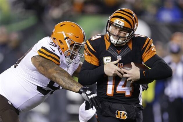 Cincinnati Bengals quarterback Andy Dalton (14) is tackled by Cleveland Browns defensive end Billy Winn (90) during the second half of an NFL football game Thursday, Nov. 6, 2014, in Cincinnati. (AP Photo/Michael Conroy)