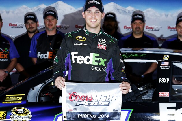 Denny Hamlin poses for photos after winning the pole position for the NASCAR Sprint Cup series auto race at Phoenix International Raceway in Avondale, Ariz., Friday, Nov. 7, 2014. (AP Photo/Rick Scuteri)