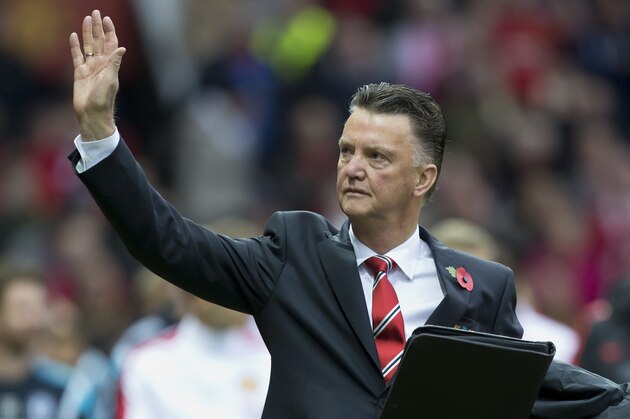 FILE - In this Sunday, Oct. 26, 2014 file photo, Manchester United's manager Louis van Gaal wears a red poppy on his lapel as he waves before his team's English Premier League soccer match against Chelsea at Old Trafford Stadium, Manchester, England. A hundred years after the Great War began, the red flowers pinned to so many coat lapels in Britain, Canada and other Commonwealth countries every Armistice Day still evoke the vivid image of bright poppies springing up from destruction and decay in Belgium's Flanders Fields, one of WWI's bloodiest battlefields. (AP Photo/Jon Super, File)