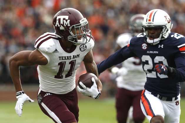 Texas A&M wide receiver Josh Reynolds (11) catches a pass and runs in for a touchdown past Auburn defensive back Johnathan Ford (23) during the first half of an NCAA college football game on Saturday, Nov. 8, 2014, in Auburn, Ala. (AP Photo/Butch Dill)
