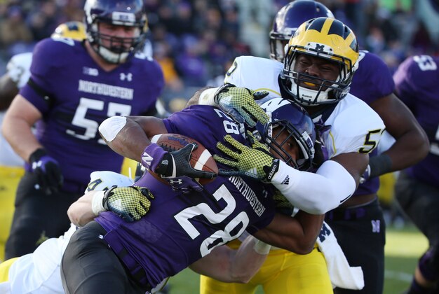 Nov 8, 2014; Evanston, IL, USA; Northwestern Wildcats running back Justin Jackson (28) is tackled by Michigan Wolverines linebacker Jake Ryan (47) and Michigan Wolverines linebacker Royce Jenkins-Stone (52) in the first half at Ryan Field. Mandatory Credit: Caylor Arnold-USA TODAY Sports