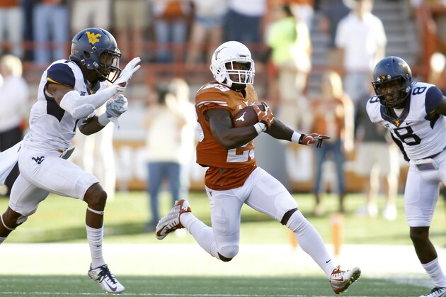 AUSTIN, TX - NOVEMBER 8: Wide receiver Daje Johnson #23 of the Texas Longhorns avoids a tackle by cornerback Daryl Worley #7 and safety Karl Joseph #8 of the West Virginia Mountaineers the NCAA Big 12 game between the Texas Longhorns and the West Virginia Mountaineers on November 8, 2014 at Darrell K. Royal-Texas Memorial Stadium in Austin, Texas. (Photo by Erich Schlegel/Getty Images)