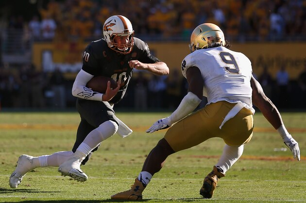 TEMPE, AZ - NOVEMBER 08:  Quarterback Taylor Kelly #10 of the Arizona State Sun Devils rushes the football against linebacker Jaylon Smith #9 of the Notre Dame Fighting Irish during the college football game at Sun Devil Stadium on November 8, 2014 in Tempe, Arizona. The Sun Devils defeated the Fighting Irish 55-31.  (Photo by Christian Petersen/Getty Images)