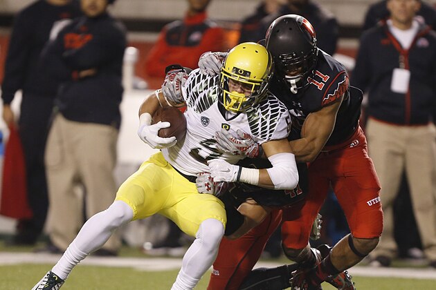 SALT LAKE CITY, UT - NOVEMBER 8:  Wide receiver Devon Allen #5 of the Oregon Ducks is tackled by defensive back Davion Orphey #11 of the Utah Utes during the first half of an NCAA football game November 8, 2014 at Rice-Eccles Stadium in Salt Lake City, Utah. (Photo by George Frey/Getty Images)