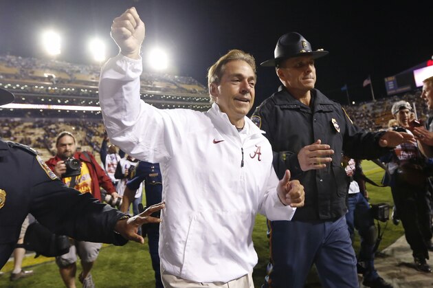 Alabama coach Nick Saban waves to fans as he runs off the field after Alabama defeated LSU 20-13 in overtime in an NCAA college football game in Baton Rouge, La., Saturday, Nov. 8, 2014.  (AP Photo/Jonathan Bachman)