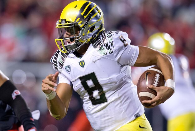 Nov 8, 2014; Salt Lake City, UT, USA; Oregon Ducks quarterback Marcus Mariota (8) runs with the ball during the second half against the Utah Utes at Rice-Eccles Stadium. Oregon won 51-27. Mandatory Credit: Russ Isabella-USA TODAY Sports