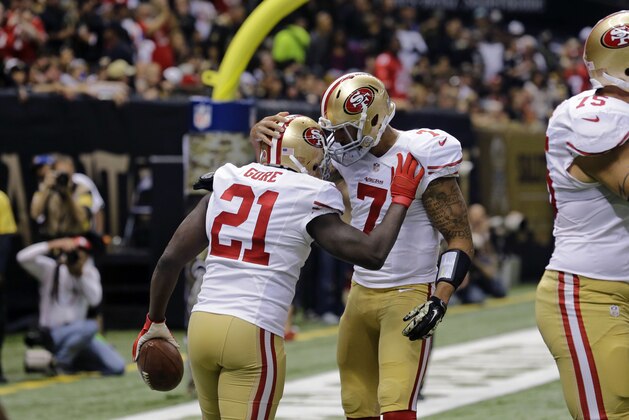 San Francisco 49ers running back Frank Gore (21) is congratulated by quarterback Colin Kaepernick (7) after scoring on a touchdown carry in the first half of an NFL football game against the New Orleans Saints in New Orleans, Sunday, Nov. 9, 2014. (AP Photo/Bill Haber)