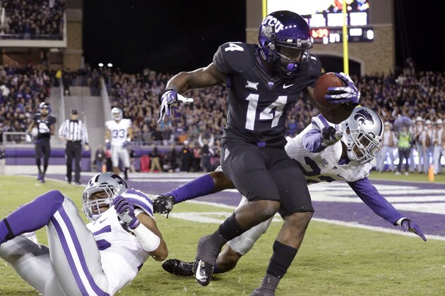 TCU wide receiver David Porter (14) makes a catch against Kansas State defensive backs Dante Barnett (22) and Randall Evans (15) during the first quarter of an NCAA college football game  Saturday, Nov. 8, 2014, in Fort Worth, Texas.  (AP Photo/LM Otero)