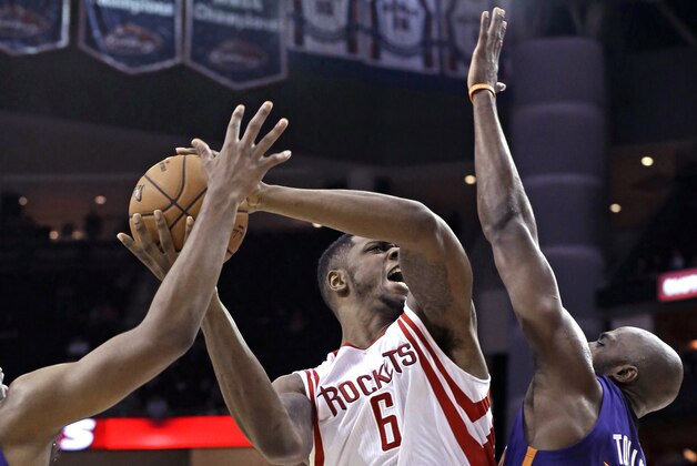 Houston Rockets' Terrence Jones (6) shoots between Phoenix Suns Anthony Tolliver (40) and T.J. Warren in the second half of an NBA exhibition basketball game Monday, Oct. 13, 2014, in Houston. The Rockets won 95-92. (AP Photo/Pat Sullivan)