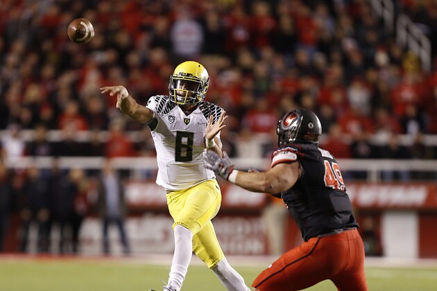SALT LAKE CITY, UT - NOVEMBER 8:  Quarterback Marcus Mariota #8 of the Oregon Ducks throws a pass  as defensive end Hunter Dimick #49 of the Utah Utes  defends during the second half of an NCAA football game November 8, 2014 at Rice-Eccles Stadium in Salt Lake City, Utah. Oregon defeated Utah 51-27. (Photo by George Frey/Getty Images)