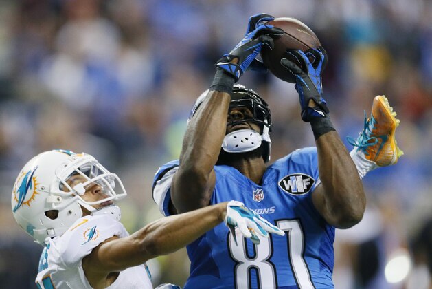Detroit Lions wide receiver Calvin Johnson (81), defended by Miami Dolphins cornerback Brent Grimes (21), catches 49-yard pass for a touchdown during the first half of an NFL football game in Detroit, Sunday, Nov. 9, 2014. (AP Photo/Rick Osentoski)