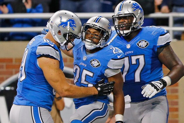 DETROIT, MI - NOVEMBER 09: Theo Riddick #25 of the Detroit Lions celebrates after scoring the game winning touchdown with teammates Kellen Davis #89 and Cornelius Lucas #77 of the Detroit Lions at Ford Field on November 09 , 2014 in Detroit, Michigan. The Lions defeated the Dolphins 20-16. (Photo by Leon Halip/Getty Images)