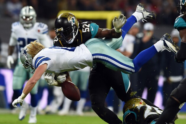 Dallas Cowboys wide receiver Cole Beasley (11) is tackled by Jacksonville Jaguars linebacker J.T. Thomas (52) during the first half of the NFL football game at Wembley Stadium, London, Sunday, Nov. 9, 2014.  (AP Photo/Tim Ireland)