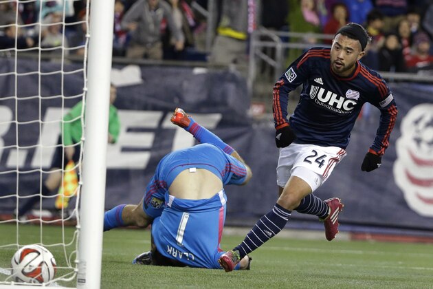 New England Revolution midfielder Lee Nguyen, right, scores as Columbus Crew goalkeeper Steve Clark, center, falls during the first half of an MLS soccer playoff game, Sunday, Nov. 9, 2014, in Foxborough, Mass. (AP Photo/Steven Senne)